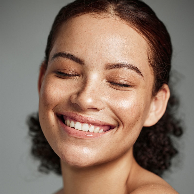 Smiling woman with natural, radiant skin.