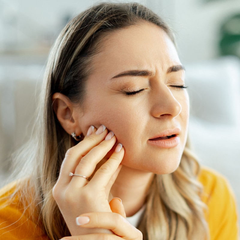 Woman experiencing pain in her jaw.