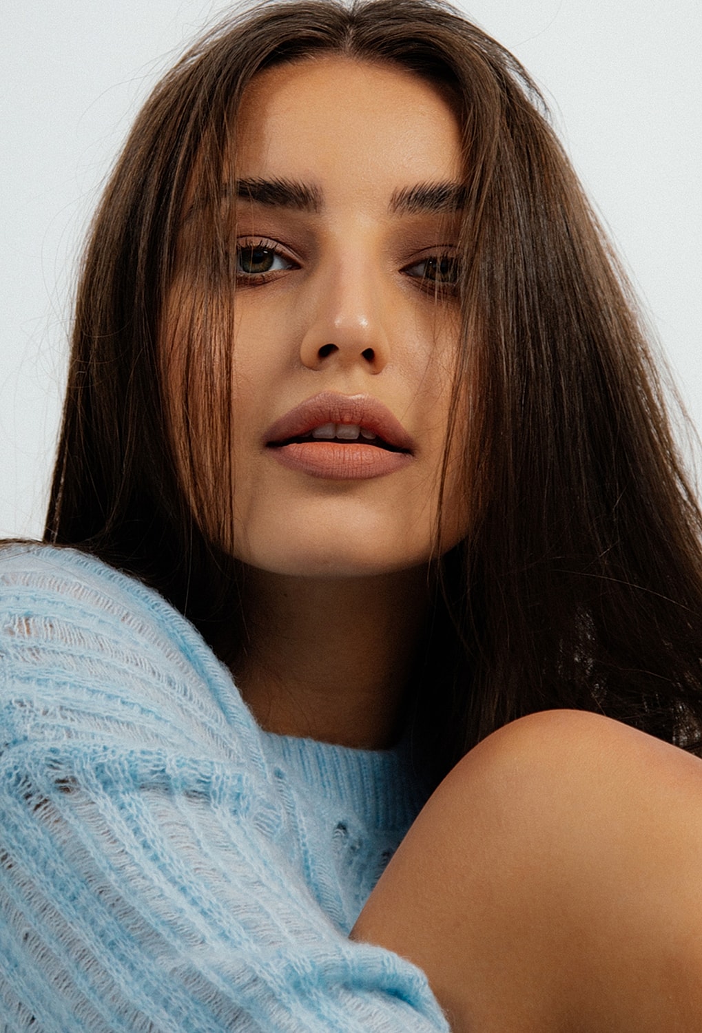 Woman with long hair in light blue sweater.