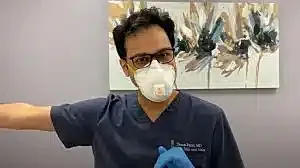 Healthcare worker in mask giving vaccination guidance.