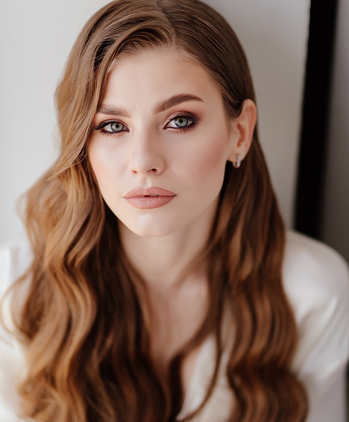 Woman with elegant hairstyle and white blouse.