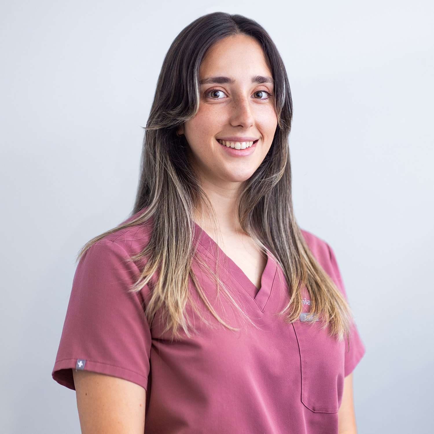 Healthcare professional smiling in scrubs.