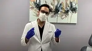 Healthcare professional wearing mask and gloves.