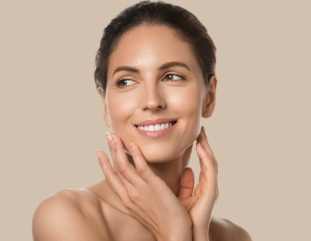 Smiling woman touching her face gently.