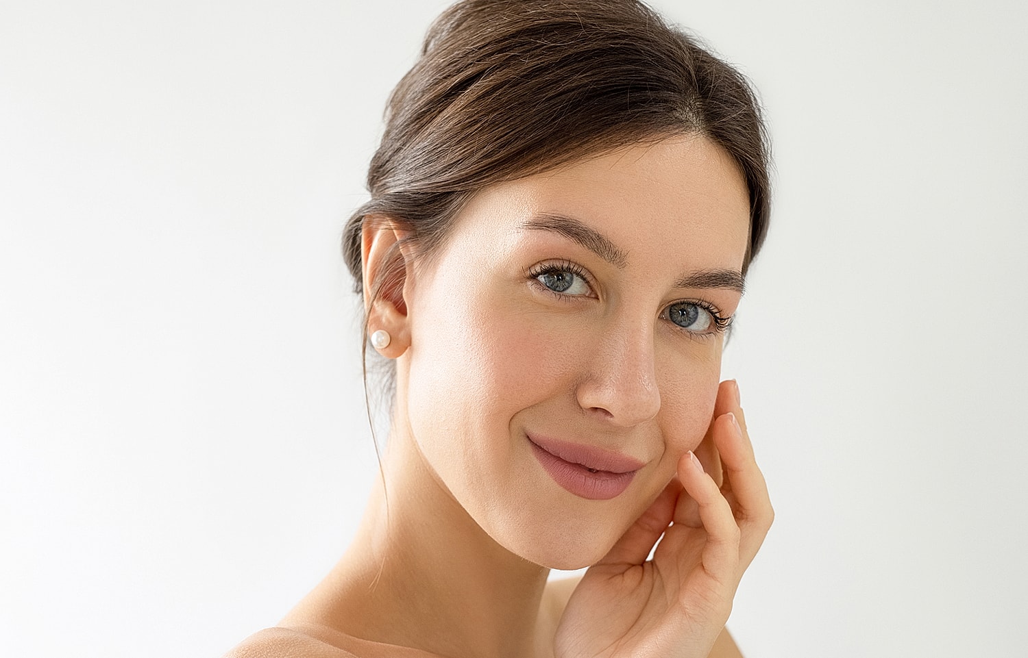 Woman smiling with hand on her face.
