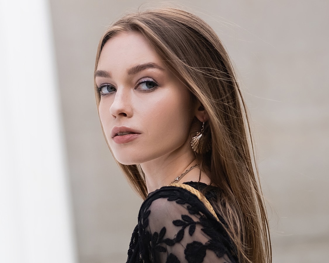 Woman with long hair in black lace outfit.