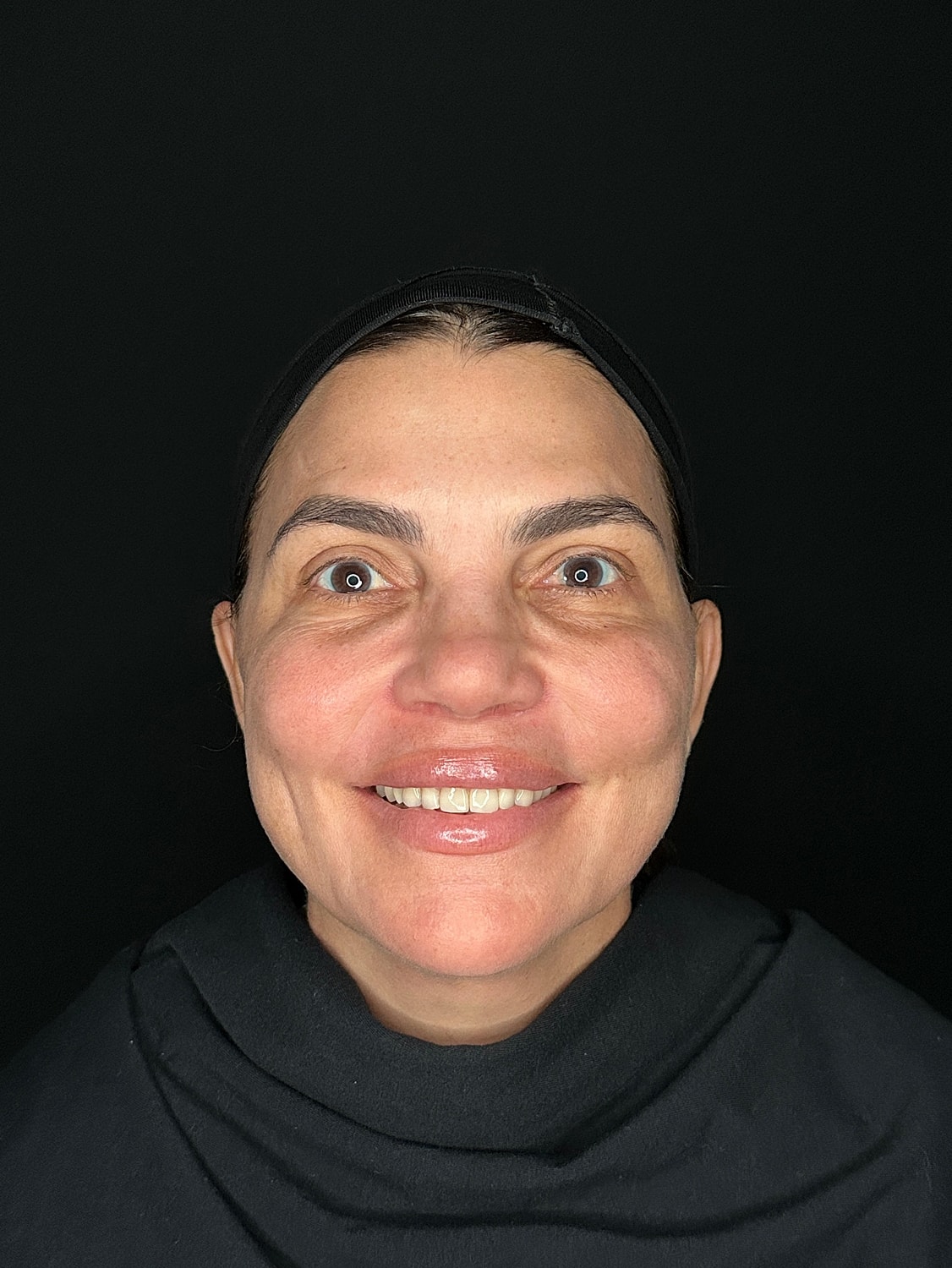 Smiling woman with natural makeup on black background