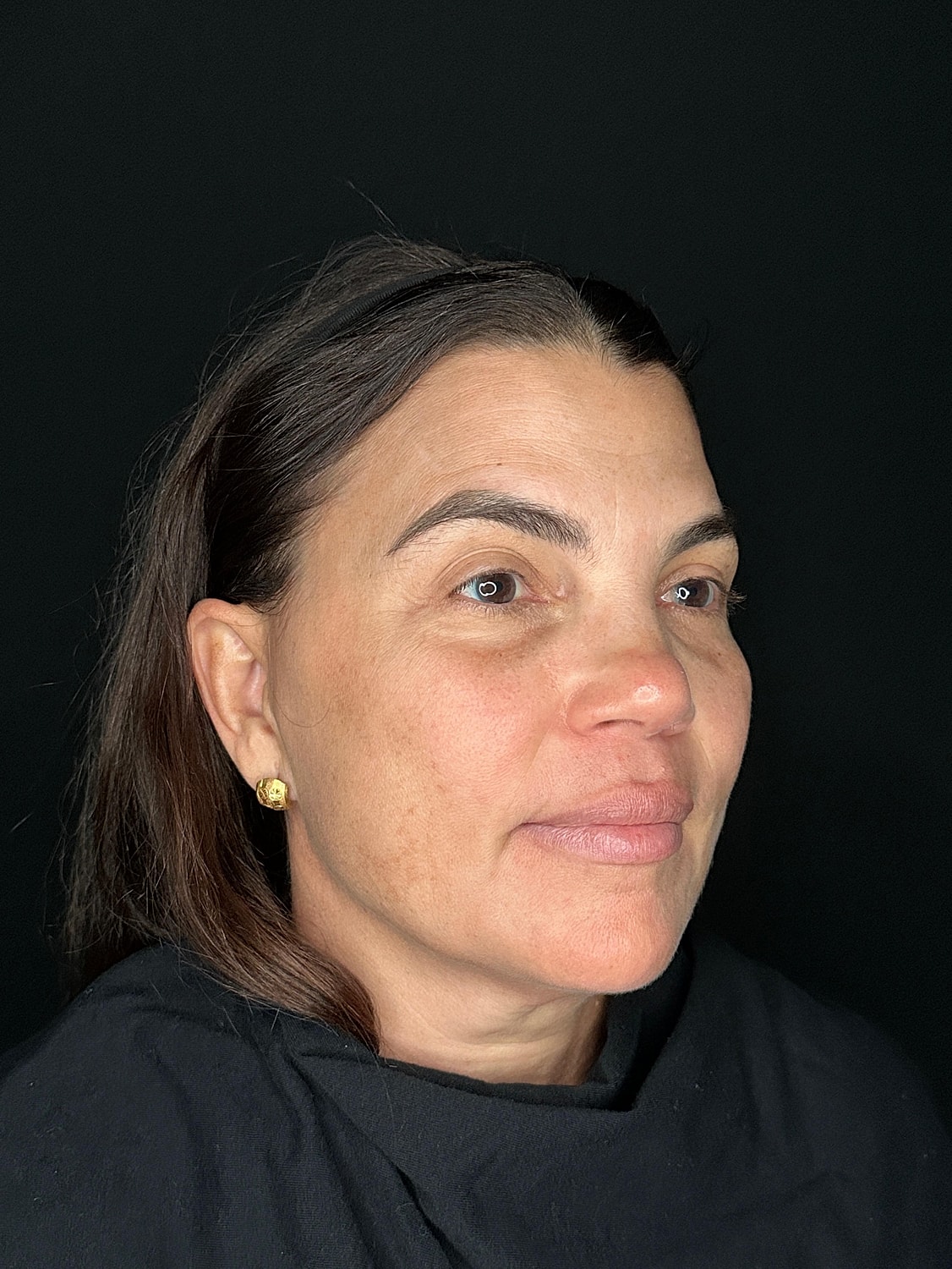 Woman with short hair and natural makeup.