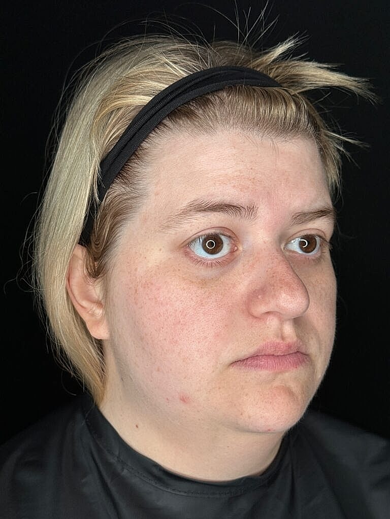 Person with light blonde hair and minimal makeup.