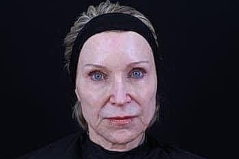Older woman with natural makeup against black background