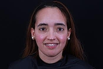 Smiling woman with long hair and earrings.