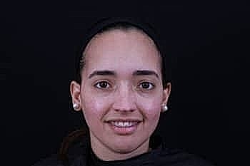 Smiling woman with light skin and black background.