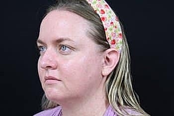 Woman with a floral headband looking thoughtfully.