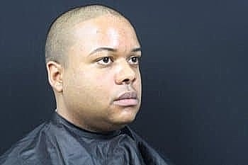Person with shaved head in barbershop setting
