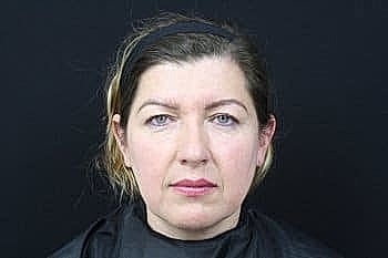Woman with serious expression against black background