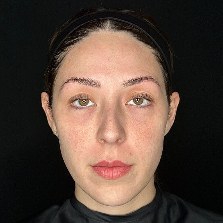 Woman with natural makeup against black background.