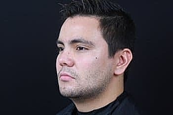 Man with short hair against black background.