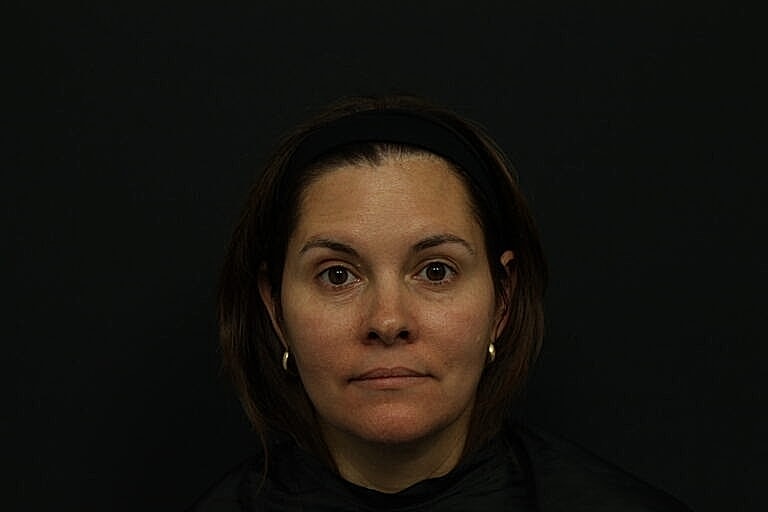 Woman with brown hair against dark background