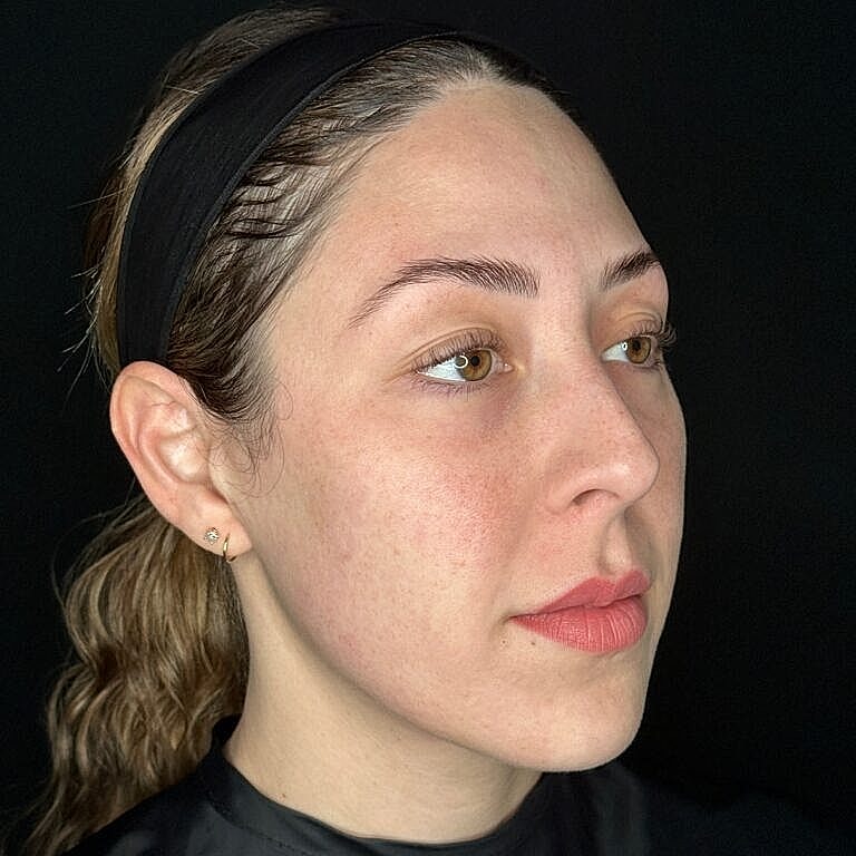 Woman with natural makeup against black background.