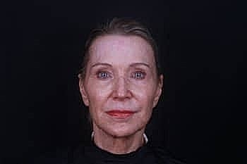 Portrait of mature woman against black background.