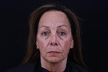 Woman's face against a dark background.