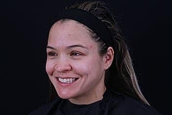 Smiling woman with a black background.