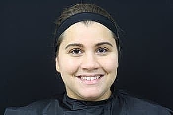 Smiling woman with dark background and hairband.