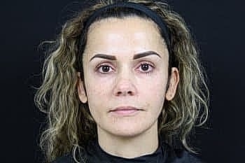 Woman with curly hair, no visible makeup.