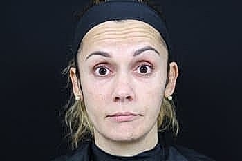 Woman with neutral expression on black background