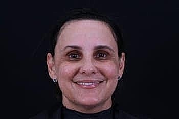 Smiling woman against a dark background.