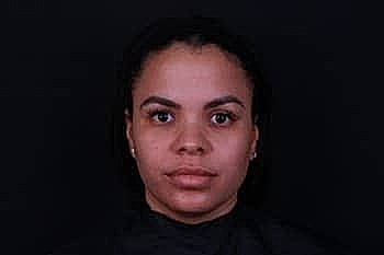 Person with neutral expression against dark background