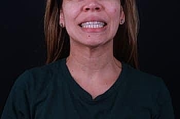 Smiling woman in a dark background.