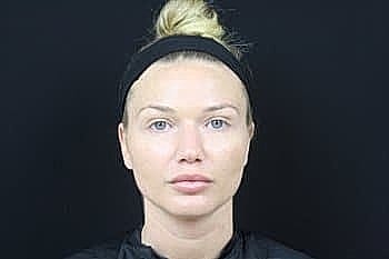 Woman with neutral expression against black background