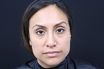 Woman with neutral expression against dark background