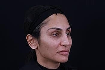 Side profile of a woman against a dark background.