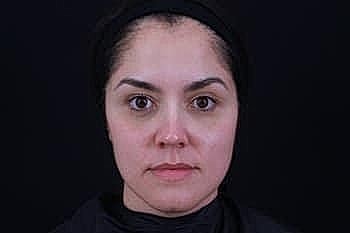 Neutral expression on female face, black background.