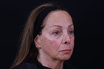 Portrait of a woman against a black background.