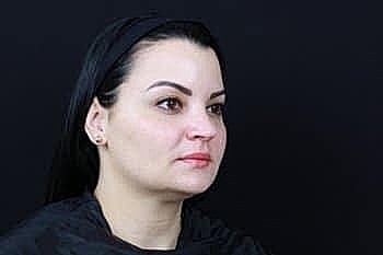 Woman with dark hair against black background