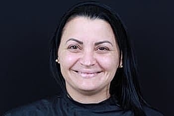 Smiling woman with long black hair.