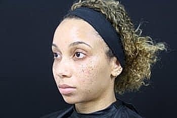 Woman with curly hair in professional setup.