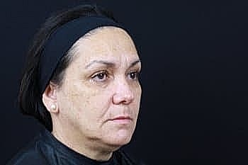 Woman looking serious against dark background.