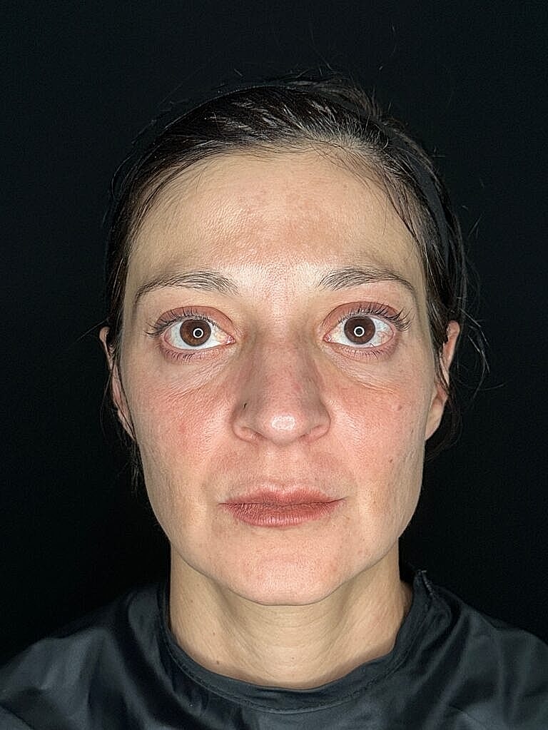 Close-up portrait of a woman with neutral expression.