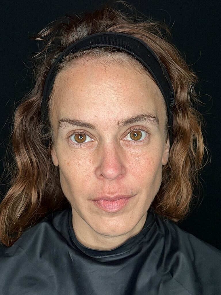 Person with wavy hair and neutral expression.