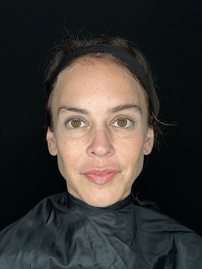 Woman with brown eyes in black backdrop.