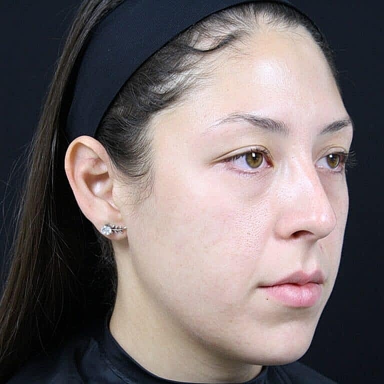 Woman with light makeup and black headband.