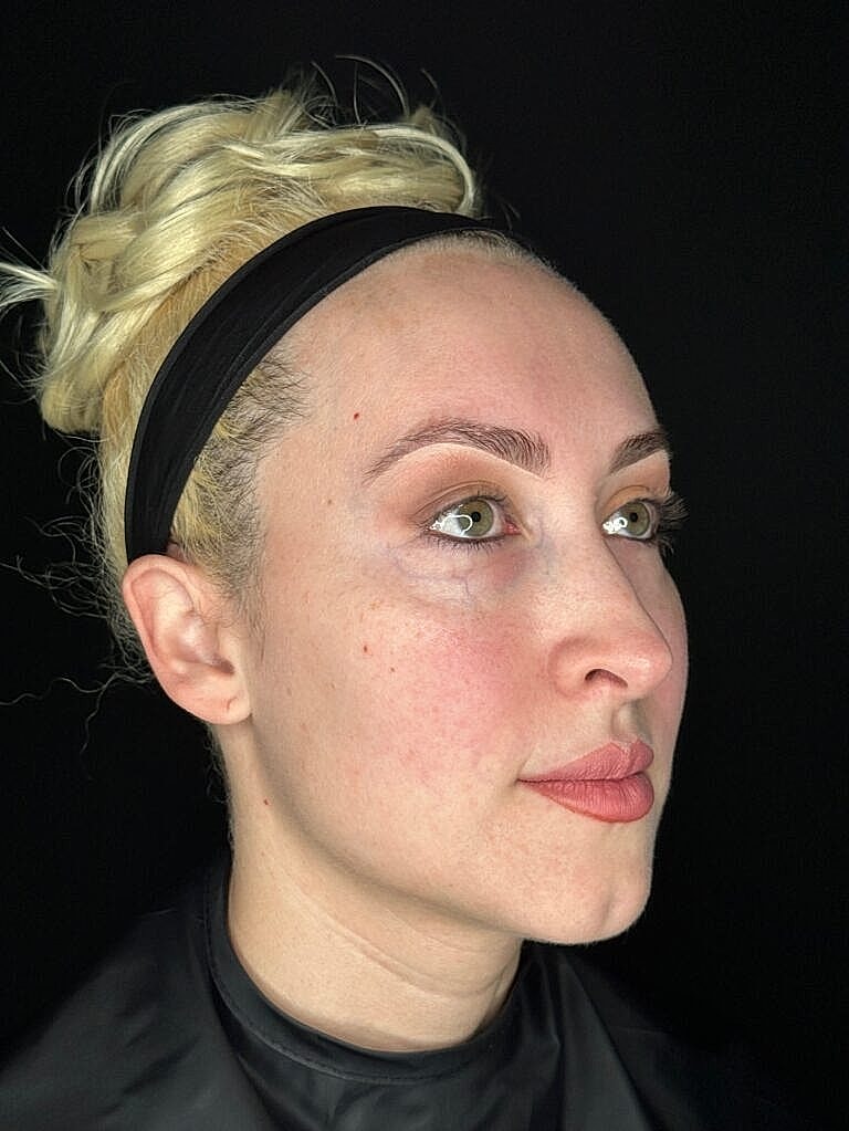 Profile of a woman with blonde hair up.