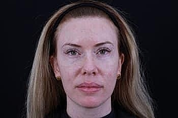 Woman with long hair against dark background.