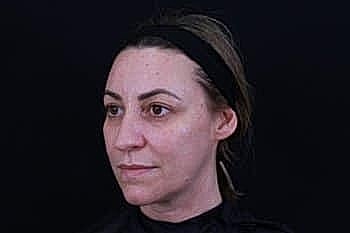 Woman with a headband against dark background.