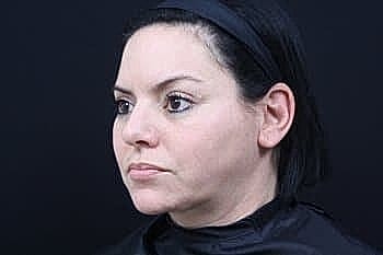 Woman with short hair against dark background