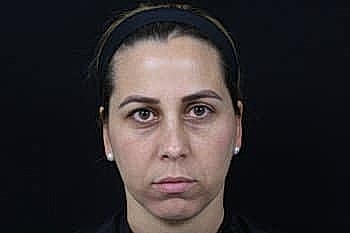 Serious woman with neutral expression on dark background